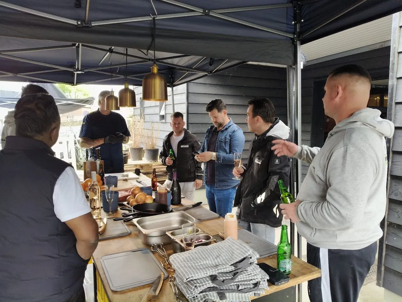 Deelnemers aan een BBQ-workshop van De Gulle Gans onder de tent