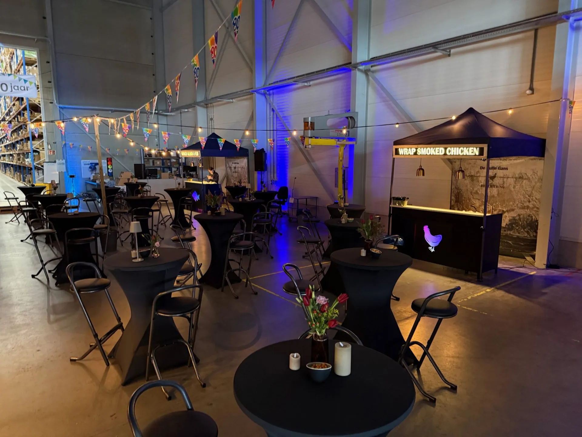 Feestzaal met statafels en de stand van De Gulle Gans
