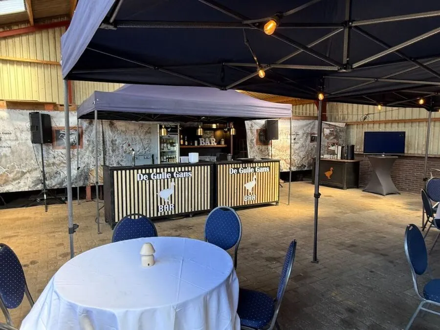Tent met tafels en verlichting, klaar voor de gasten